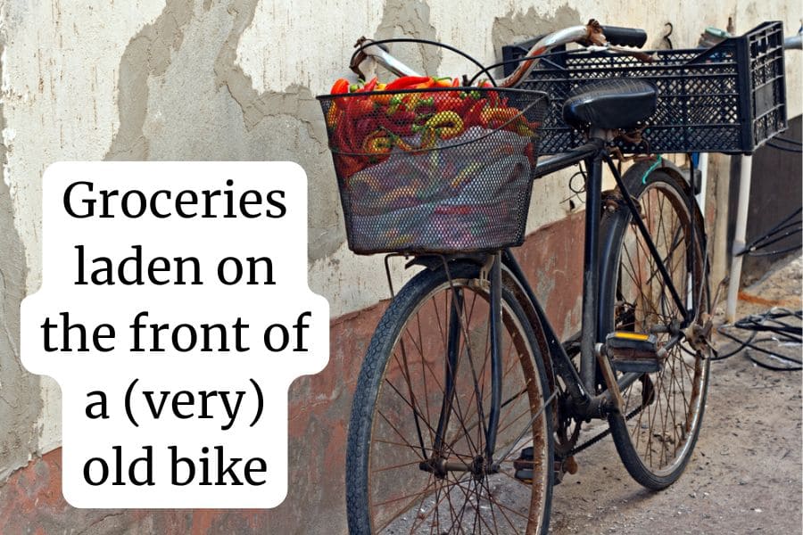 Groceries laden on the front of an old bike