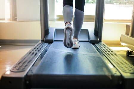 Woman running on treadmill in gym