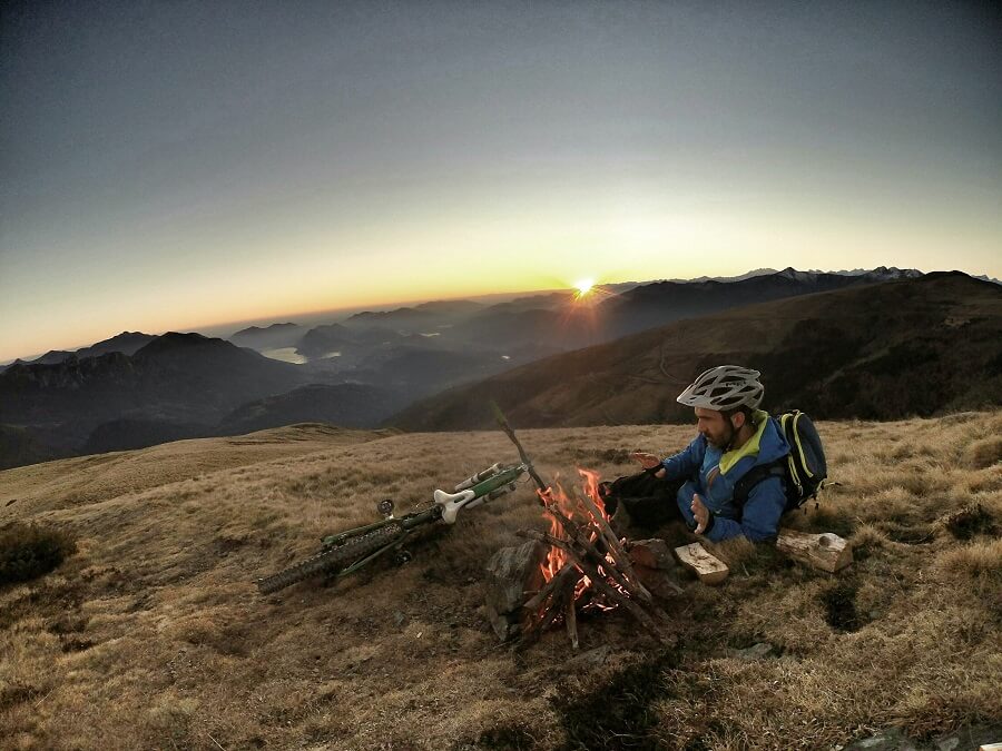 Bring correct bike gear - Bikepacking cyclist sitting beside campfire