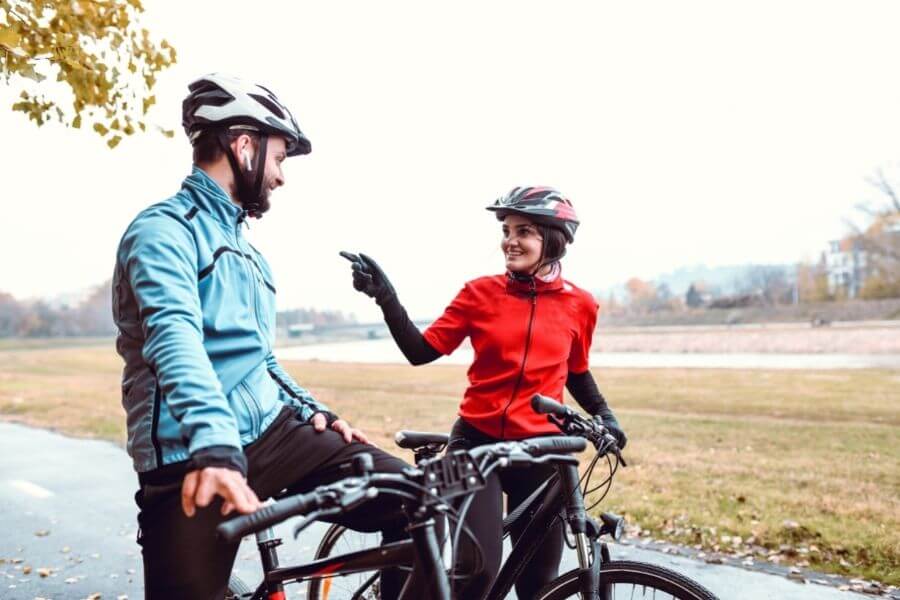 Cyclist lovely couple riding bicycle smiling and enjoying daytime in park