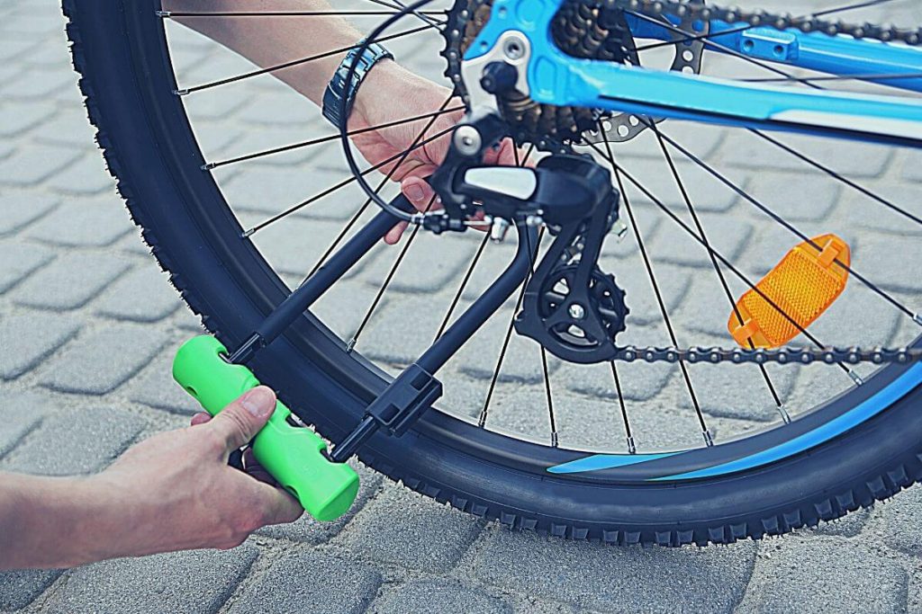 man locking bike with green U-lock mount
