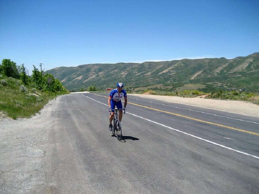 male cyclist biking on the road going uphill Emigration Canyon - Flickr image