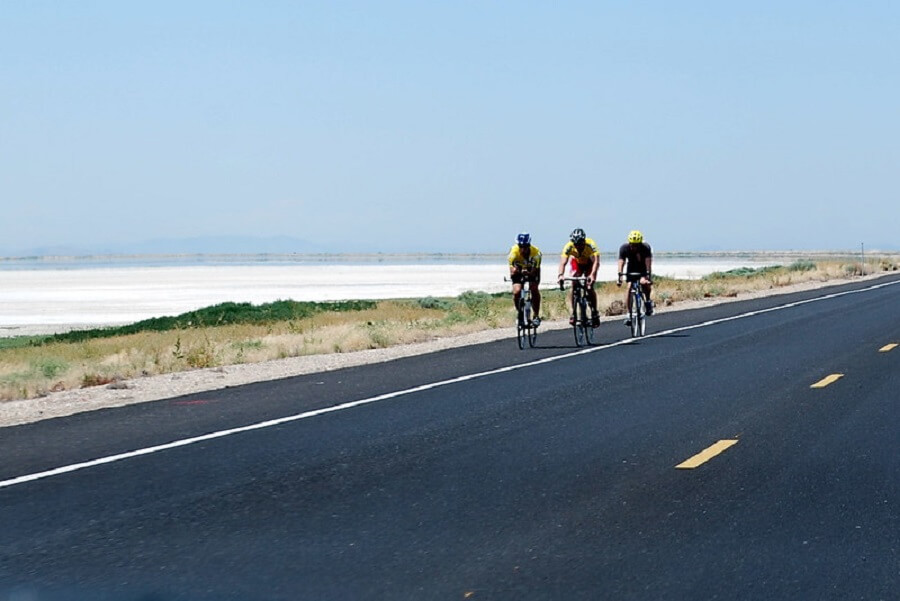 three adult cyclists biking on the road of Antelope Island, Utah on sunny day - Flickr image