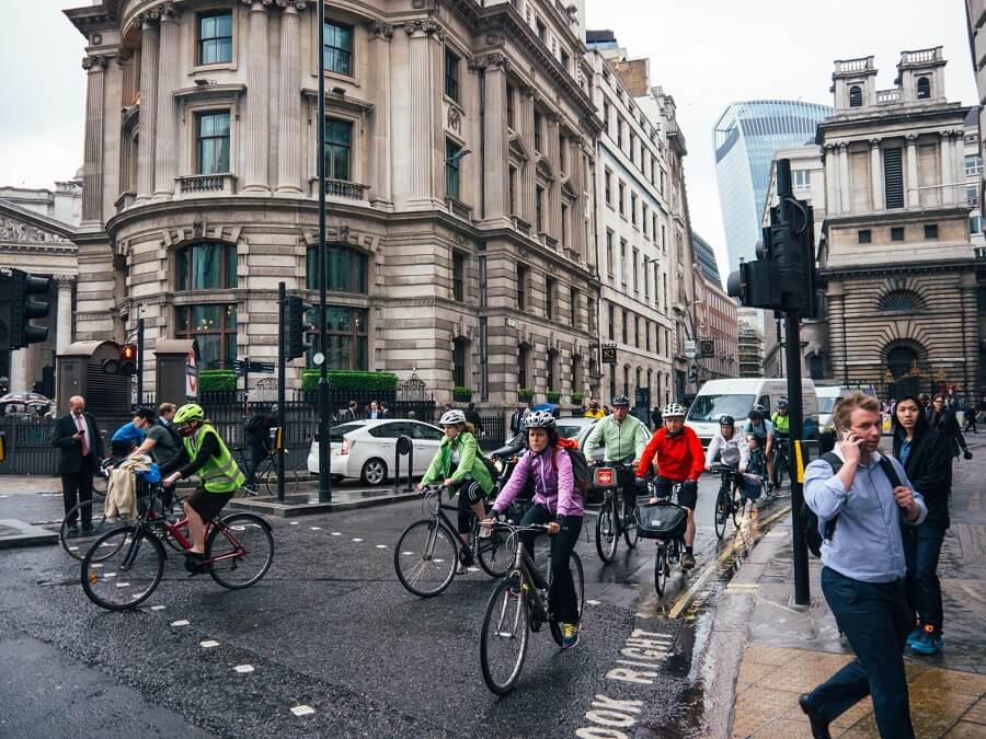 Group of bike commuters cycling around the traffic road