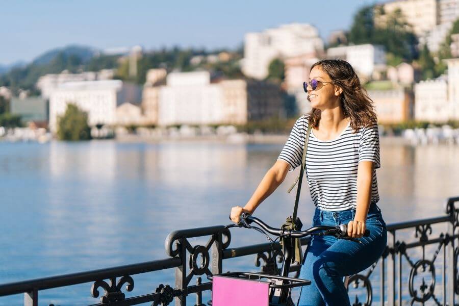 Cheerful female commuter riding on bike enjoying the scenery