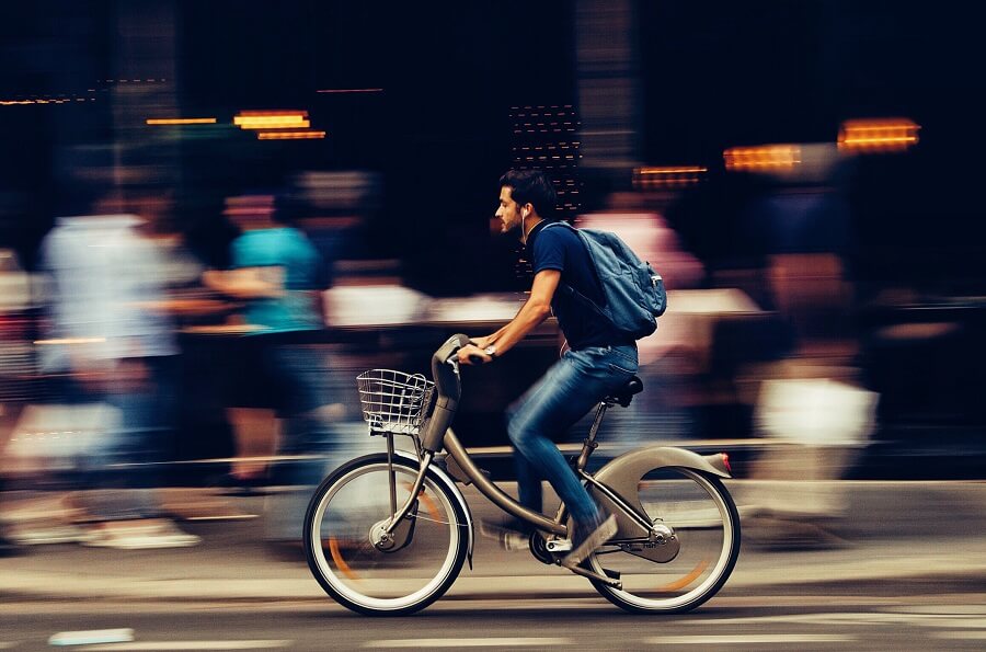 Man riding a rental bike through a city