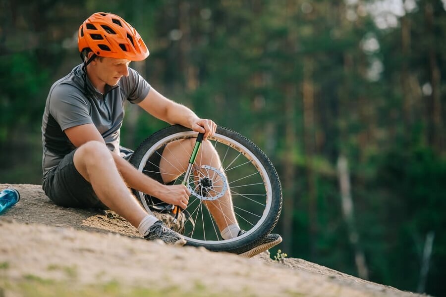 Man pumping up mountain bike type in the wild