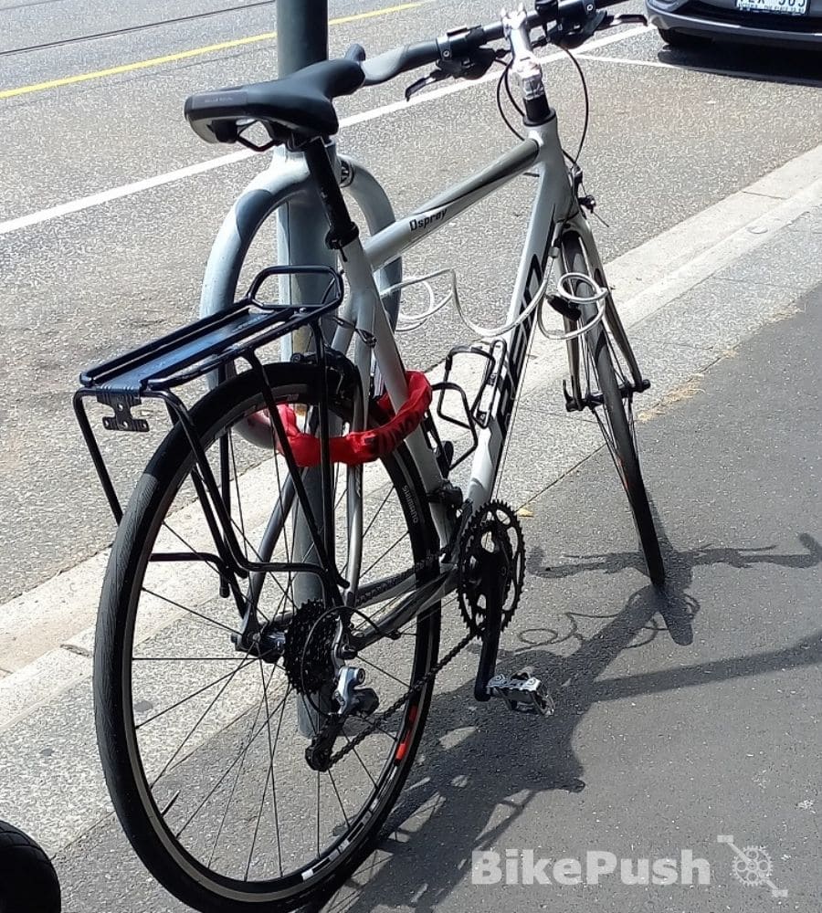 Bike locked against lamppost with extra rack on the post