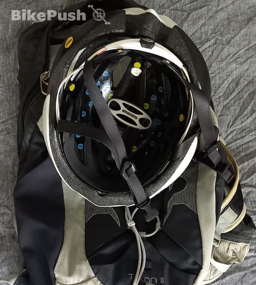 Bike helmet attached to a backpack with a helmet clamp accessory