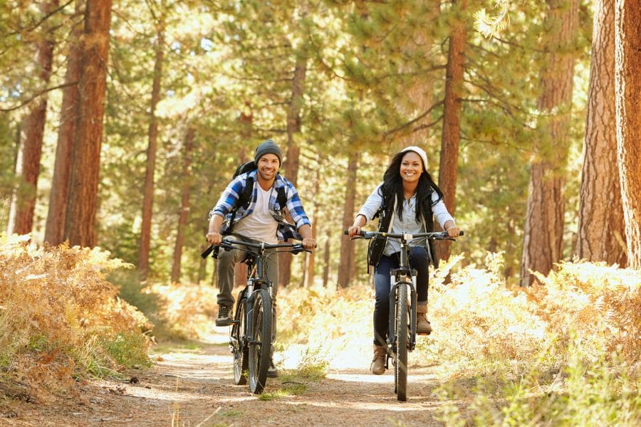happy couple riding mountain bikes on a trail