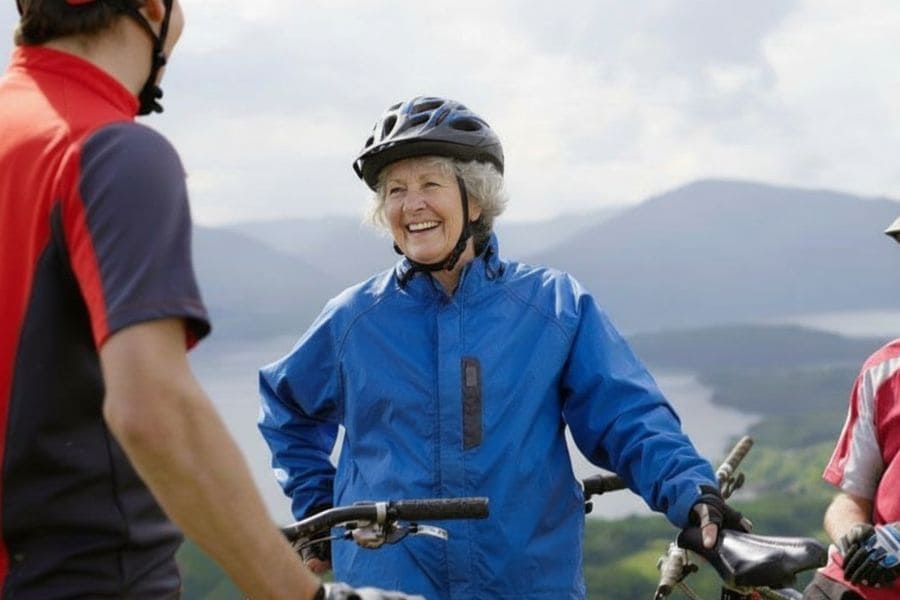 old lady in blue jacket resting on bike ride