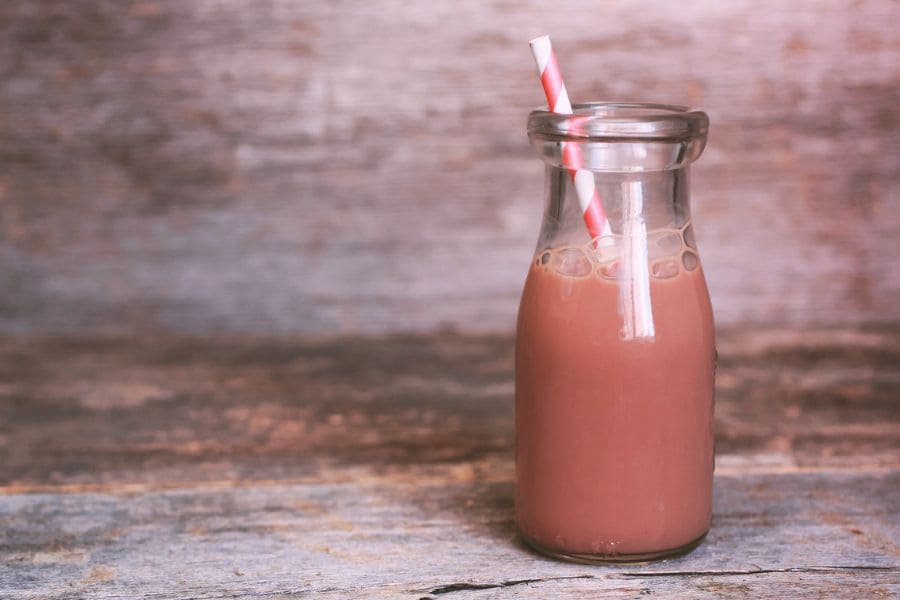 Chocolate milk in a glass bottle with a straw